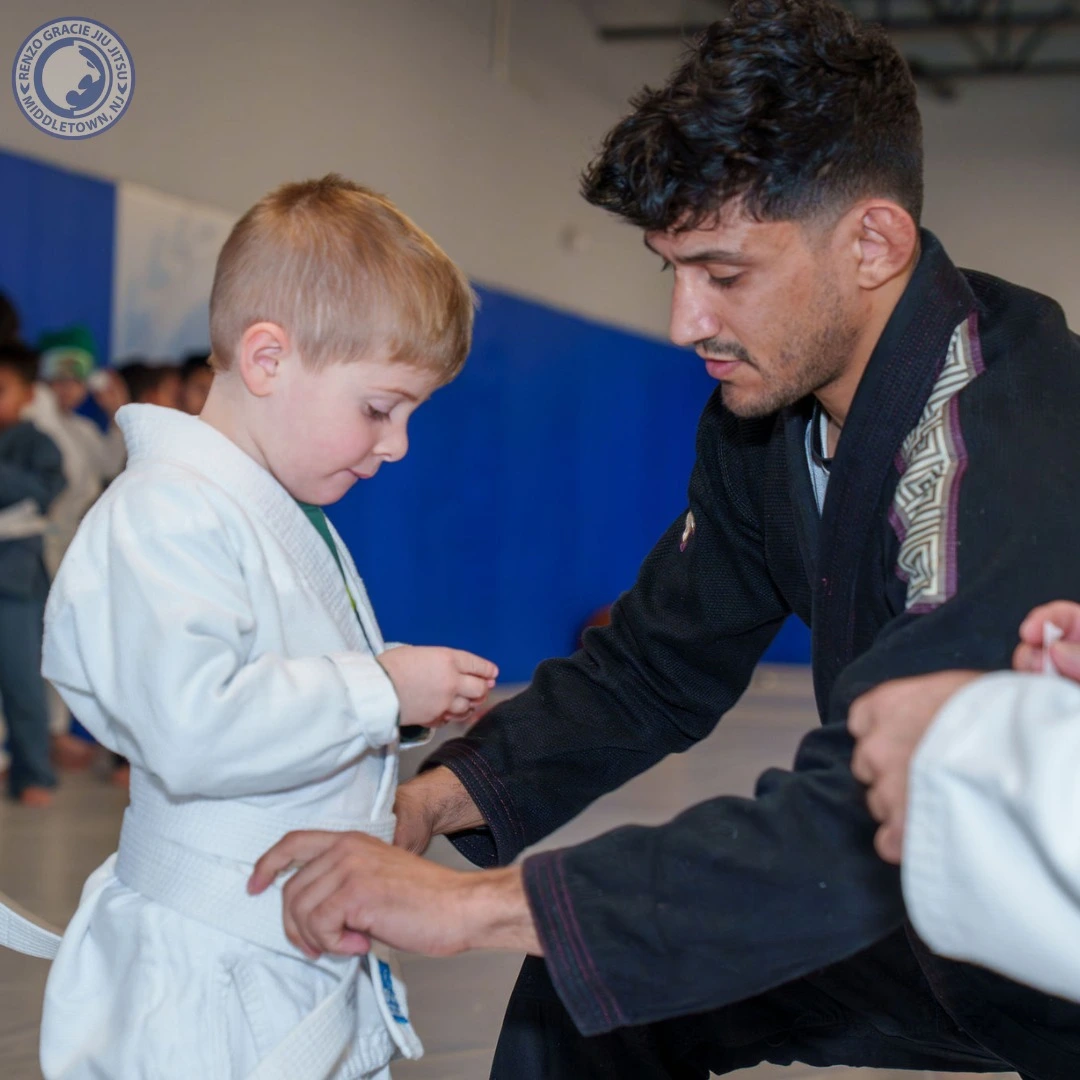 Renzo Gracie Middletown coach tying belt on a 4-year-old white-belt